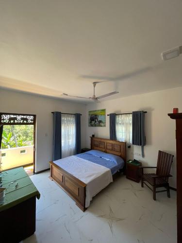 a bedroom with a bed and a desk and a window at Villa Talpe in Talpe