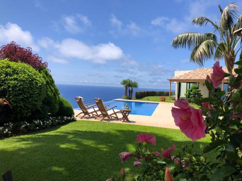 un cortile con piscina e oceano di Morning Star Villa ad Arco da Calheta