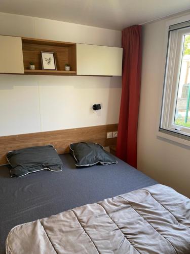 - une chambre avec un lit avec deux oreillers et une fenêtre dans l'établissement Mobilhome Sables du midi, à Valras-Plage