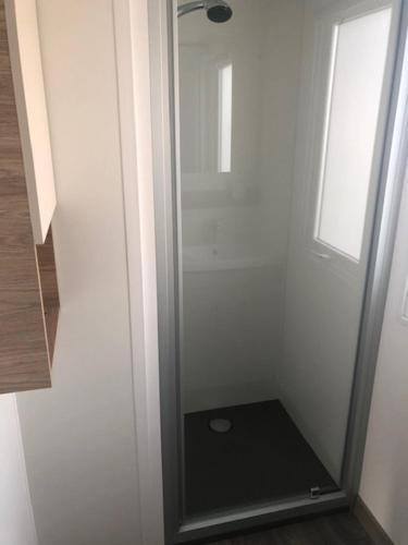 - un miroir dans une chambre blanche avec une fenêtre dans l'établissement Mobilhome Sables du midi, à Valras-Plage