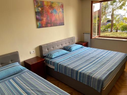 een slaapkamer met 2 bedden en een raam bij Apartments Leko in Portorož