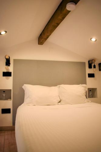a bedroom with a large bed with white pillows at Casa Malpique in Albufeira