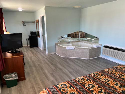 a hotel room with a tub and a television at Crow's Nest in Tawas City