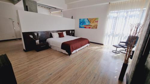 1 dormitorio con 1 cama y 1 silla en Habitat Suites Hotel, en Pereira