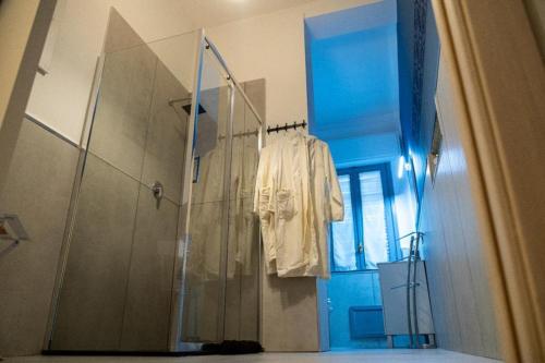 a bathroom with a shower with a white robe hanging from it at Exclusive in Palermo