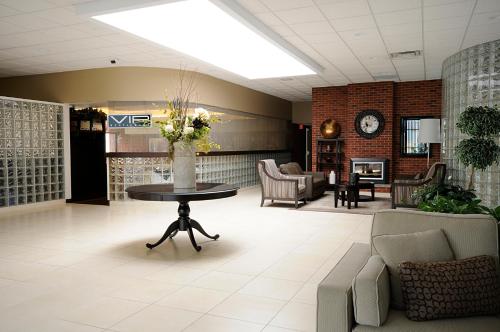 a lobby with a table and chairs and a fireplace at Visitor's Inn in Hamilton