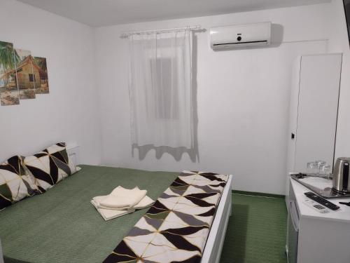 a room with a bed in a kitchen with a table at Vila Atipic in Costinesti