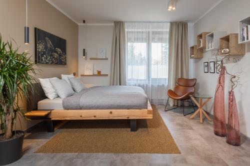 um quarto com uma cama, uma cadeira e uma janela em Redfoxapartment Garden em Kašperské Hory