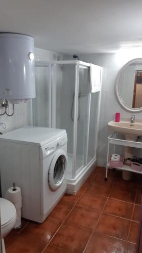 a bathroom with a washing machine and a toilet at Casa Rural San Miguel in Saúca