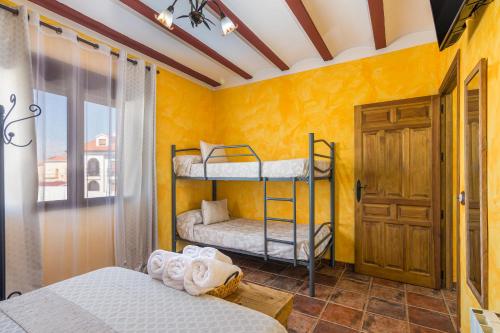 a bedroom with two bunk beds and a yellow wall at El Mirador De Ruidera in Ruidera