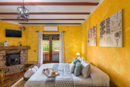 a yellow bedroom with a bed and a fireplace at El Mirador De Ruidera in Ruidera
