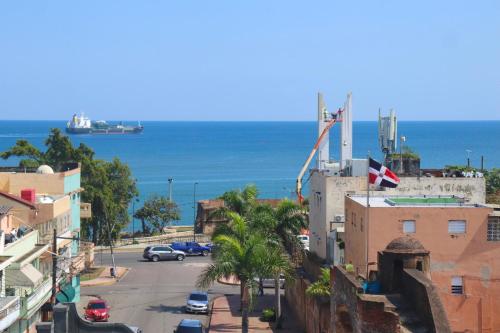 una calle de la ciudad con edificios y el océano en el fondo en Hotel Enrique II Zona Colonial, Bed and Breakfast en Santo Domingo