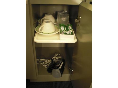 a shelf in a cupboard with a plate and dishes on it at Grand Central Hotel - Vacation STAY 19605v in Tokyo