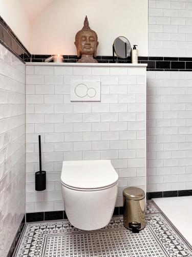 een witte badkamer met een toilet en een bad bij SOLÉY in Sohland am Rotstein