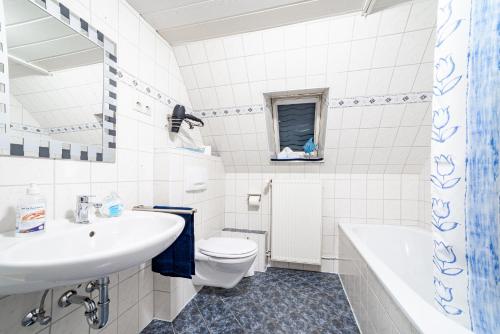 a white bathroom with a sink and a toilet at Ferienwohnung Gerda in Lathen