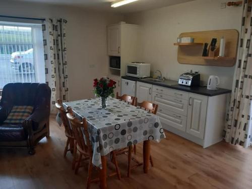 een keuken en eetkamer met een tafel en stoelen bij Skellig View Sunset Cliffs View Apartment in Portmagee