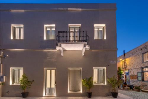 - un bâtiment avec un balcon sur le côté dans l'établissement Times Elegant Rooms, à Ermoúpoli