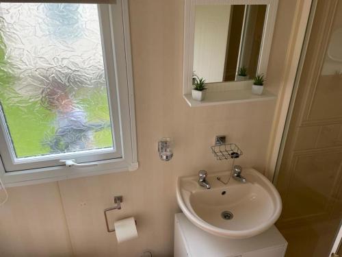 a bathroom with a sink and a toilet and a window at Southfield 97 in Great Driffield