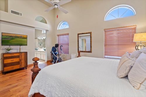 a bedroom with a large white bed and windows at Spa, Covered Patio Upscale Phoenix Oasis! in Peoria