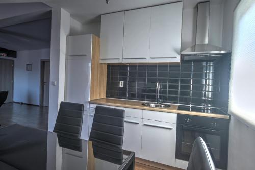 a kitchen with white cabinets and a table with chairs at Panorama in Rakovica