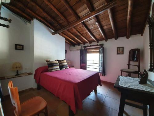 a bedroom with a red bed in a room at Casita del Niño Rey in Montejaque