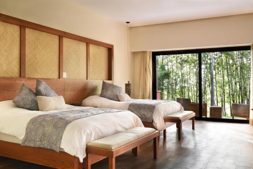 a bedroom with three beds and a large window at Casa Soul Spring in Xochitepec