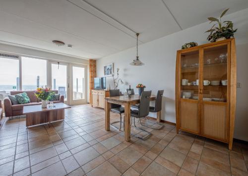 a living room with a table and a couch at Appartementen De Buteriggel in De Koog