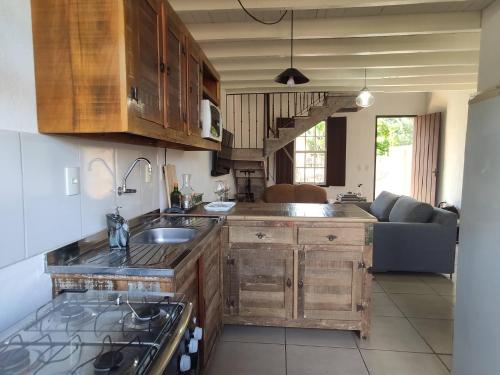 eine Küche mit Holzschränken und ein Wohnzimmer in der Unterkunft Vila Santana Tiradentes in Tiradentes