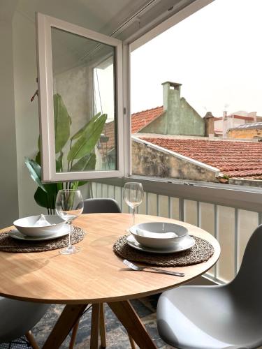 a wooden table with two wine glasses and a window at Luxury apartment in center Cascais in Cascais