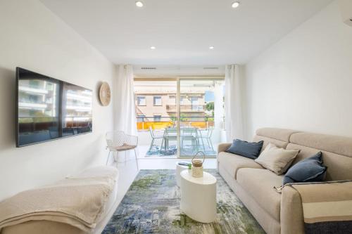 a white living room with a couch and a table at SERRENDY 2-bedroom apartment near Croisette in Cannes