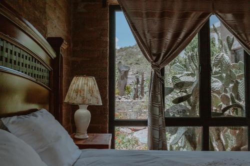 a bedroom with a bed and a large window at Lavanda Aldea Holística in San Miguel de Allende