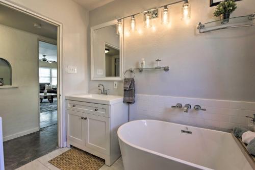 a white bathroom with a tub and a sink at 2 Mi to Dtwn Phoenix Cottage with Private Yard! in Phoenix
