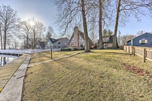 a home with a wooden walkway next to a bridge at Spacious Syracuse Getaway with Waterfront Deck! in Syracuse