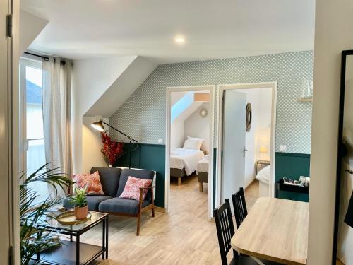 Una sala de estar con un sofá y un dormitorio. en Émeraude Lumineux T3 au cœur du village, à 5 min des plages, en Saint-Méloir-des-Ondes