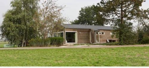 una pequeña casa en un campo al lado de un patio en Beautiful Countryside house, close to Amsterdam en Broek in Waterland