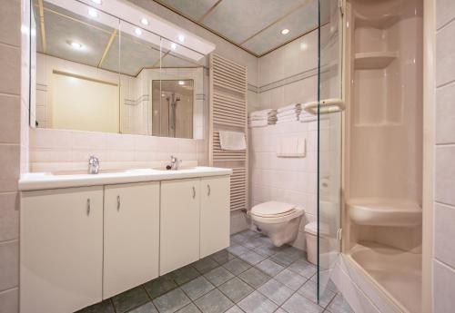 a bathroom with a toilet and a sink and a shower at Appartementen De Buteriggel in De Koog