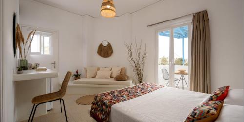 a bedroom with a bed and a chair and a couch at Cal Day Rooms Santorini in Perissa