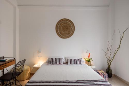 a bedroom with a large bed and a desk at Cal Day Rooms Santorini in Perissa