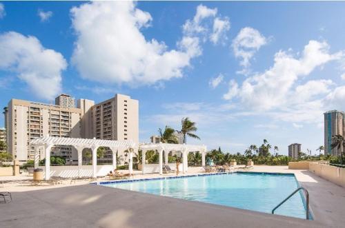 a swimming pool with a gazebo next to buildings at Hawaiian Monarch 1804 condo in Honolulu