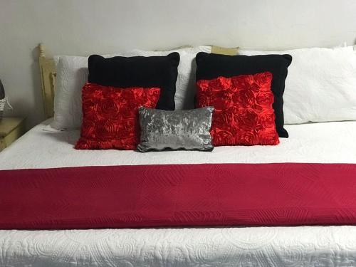 Una cama con almohadas rojas y negras. en Casa Díaz Habitacion Diamante, en Parras de la Fuente