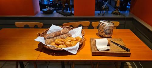 einen Tisch mit einem Korb Brot und einem Teller Brot in der Unterkunft Hotel & Restaurant Sternen Köniz bei Bern in Bern