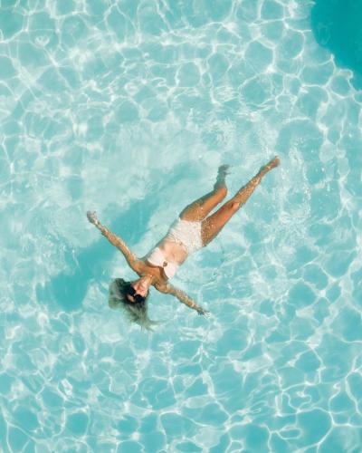 a woman floating in a pool of water at The Frenchie in Round Top
