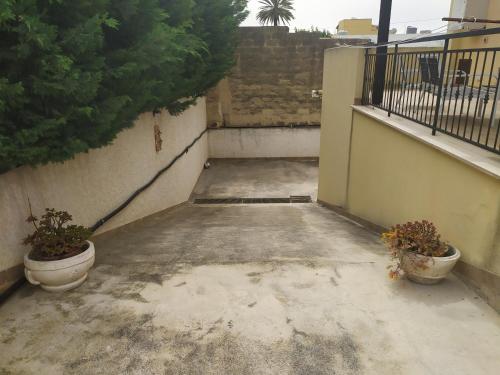a balcony with two potted plants on a building at Oro&Mattia's House in Trapani