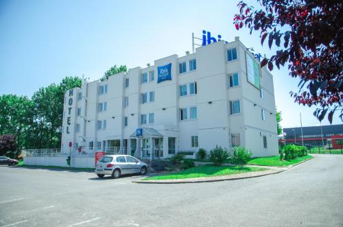 a white building with a car parked in front of it at ibis budget Aeroport le Bourget Garonor in Le Blanc-Mesnil