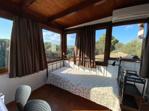 a bedroom with a bed in a room with windows at Villa Paradisino in Orbetello