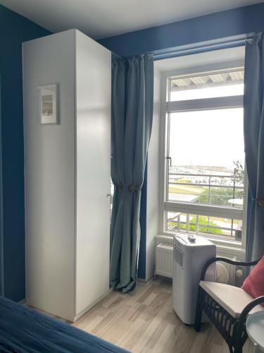 a bedroom with a window and a bed and a door at Havudsigt, skøn lille lejlighed in Tranekær