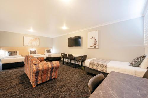 a hotel room with two beds and a couch at Fitzroy Motor Inn in Grafton
