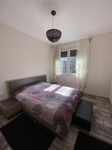 a bedroom with a large bed in front of a window at Apartmani Vila in Cetinje