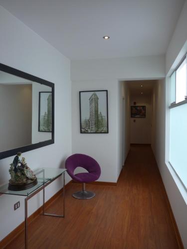 a room with a glass table and a purple chair at Spacious Apartment in Miraflores in Lima