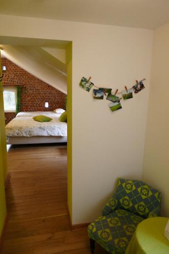 a bedroom with a bed and some pictures on the wall at B&B La ferme de Berwausault in Herve